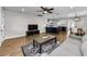Living room featuring wood flooring, stylish blue rug, and an open layout with access to the kitchen and dining at 1800 Mapleleaf Blvd, Oldsmar, FL 34677