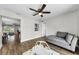 Bright living room with wood floors, gray chaise lounge, and view of eat-in kitchen at 1800 Mapleleaf Blvd, Oldsmar, FL 34677