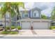 Charming townhome showcasing curb appeal with palm trees and a two-car garage at 18136 Nassau Point Dr, Tampa, FL 33647