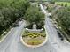 Aerial view of Claridge Place entrance with manicured landscaping, trees, and surrounding neighborhood streets at 2349 Willimette Dr, Wesley Chapel, FL 33543