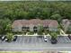 Aerial view of townhouses with parking, surrounded by lush greenery and a beautiful wooded area at 2349 Willimette Dr, Wesley Chapel, FL 33543
