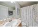 Bathroom vanity featuring a sink, a mirror, and a white shower curtain with a floral design at 2349 Willimette Dr, Wesley Chapel, FL 33543