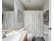 Bathroom features a white shower curtain with a floral design and light gray walls at 2349 Willimette Dr, Wesley Chapel, FL 33543