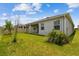 Manicured backyard with a covered patio and vinyl privacy fence at 2518 Chapel Oak Bnd, Wesley Chapel, FL 33543