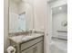 Well-lit bathroom with granite countertops, vanity sink, and a glimpse of additional space beyond at 2518 Chapel Oak Bnd, Wesley Chapel, FL 33543
