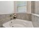 Close up of bathtub with tile surround and window at 2518 Chapel Oak Bnd, Wesley Chapel, FL 33543