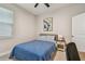 Bright bedroom with a desk area for work, a stylish patterned blue coverlet, and ample natural light at 2518 Chapel Oak Bnd, Wesley Chapel, FL 33543