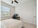 Simple bedroom setup with a desk for a workspace, a comfy bed, and a sunny window at 2518 Chapel Oak Bnd, Wesley Chapel, FL 33543
