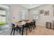 Bright dining area with a wooden table set for eight, neutral walls, and sliding glass doors to the outside at 2518 Chapel Oak Bnd, Wesley Chapel, FL 33543