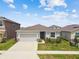 Inviting single-story home with two-car garage, stone veneer accents, and well-manicured lawn under a partly cloudy sky at 2518 Chapel Oak Bnd, Wesley Chapel, FL 33543
