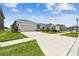 View of multiple single-story homes featuring two-car garages, stone accents, and well-kept lawns on a sunny day at 2518 Chapel Oak Bnd, Wesley Chapel, FL 33543