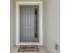 Inviting front door featuring a sidelight, decorative welcome mat, and neutral gray trim at 2518 Chapel Oak Bnd, Wesley Chapel, FL 33543