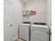 Functional laundry room equipped with a side-by-side washer and dryer plus storage shelves at 2518 Chapel Oak Bnd, Wesley Chapel, FL 33543