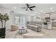 Bright living room with gray sofa, stylish chairs, and sliding glass doors to the backyard at 2518 Chapel Oak Bnd, Wesley Chapel, FL 33543