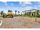 Community playground with swings and climbing structures with homes visible in the background at 2518 Chapel Oak Bnd, Wesley Chapel, FL 33543