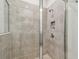 Tiled shower with glass door, shower niche, and modern fixtures at 2518 Chapel Oak Bnd, Wesley Chapel, FL 33543
