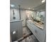 Modern bathroom with granite countertops, white cabinetry, and a glass-enclosed shower with stylish fixtures at 2716 11Th Ct, Palm Harbor, FL 34684