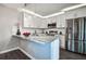 Modern kitchen with stainless steel appliances, white cabinets, and a stylish breakfast bar at 2716 11Th Ct, Palm Harbor, FL 34684