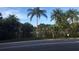Scenic street view of a tranquil lake fringed by a variety of lush, mature palm trees at 2716 11Th Ct, Palm Harbor, FL 34684