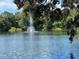 Scenic view of a pond with a water fountain surrounded by trees at 2716 11Th Ct, Palm Harbor, FL 34684