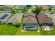 Aerial view of a home featuring a screened-in pool, lush lawn, and neighborhood setting at 31241 Kirkshire Ct, Wesley Chapel, FL 33543