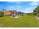 Expansive backyard featuring a well-maintained lawn and a screened enclosure with a swimming pool at 31241 Kirkshire Ct, Wesley Chapel, FL 33543