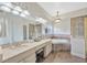 Bright bathroom features double sinks, soaking tub, tiled floors, and neutral color palette at 31241 Kirkshire Ct, Wesley Chapel, FL 33543