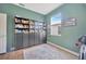 Room with dark green walls, wood floors and built-in bookshelves with decorative touches at 31241 Kirkshire Ct, Wesley Chapel, FL 33543