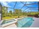 Inviting screened pool and spa with a scenic view of the lush green backyard and mature trees at 31241 Kirkshire Ct, Wesley Chapel, FL 33543