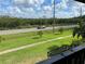 Enjoy green space view with palm trees, a road, and lush foliage from this balcony at 320 N Bayshore Blvd # 203, Clearwater, FL 33759