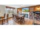 Inviting dining room features a fireplace, brick wall, and large window for abundant natural light at 3743 Cherrywood Dr, Holiday, FL 34691
