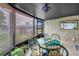 Cozy screened-in patio with a round table and green chairs at 3743 Cherrywood Dr, Holiday, FL 34691
