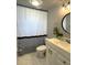 Well-lit bathroom featuring a vanity with storage and a shower with black and white curtains at 3811 Elmwood Dr, Holiday, FL 34691
