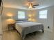 Cozy bedroom with a ceiling fan and plush bedding, illuminated by soft bedside lamps at 3811 Elmwood Dr, Holiday, FL 34691