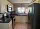 Updated kitchen with stainless steel appliances, black countertops, and bright, natural light at 3811 Elmwood Dr, Holiday, FL 34691