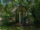 Rustic outbuilding with overgrown foliage, offering potential for creative restoration or repurposing at 4205 Old Mulberry Rd, Plant City, FL 33567