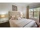 Comfortable bedroom with a tufted headboard, side tables, and a window with natural light at 4221 W Spruce St # 2328, Tampa, FL 33607