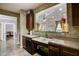 This kitchen area features a unique cutout over the sink, with dark cabinets and neutral countertops at 4221 W Spruce St # 2328, Tampa, FL 33607