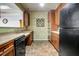 This kitchen features wooden cabinets, a black dishwasher, neutral countertops and patterned wallpaper at 4221 W Spruce St # 2328, Tampa, FL 33607