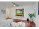 Bright living room with hardwood floors, ceiling fan, and mounted TV with built-in shelving at 4221 W Spruce St # 2328, Tampa, FL 33607
