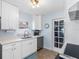 A well-lit kitchen with white cabinetry and stainless-steel dishwasher has a window above the sink at 429 87Th Ave, St Pete Beach, FL 33706