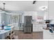 Kitchen with white cabinets and stainless steel refrigerator is adjacent to a dining area at 429 87Th Ave, St Pete Beach, FL 33706