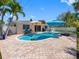 This backyard features a gorgeous private pool and spa surrounded by a brick patio and lush tropical landscaping at 429 87Th Ave, St Pete Beach, FL 33706