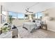 Bright bedroom featuring a modern ceiling fan, and expansive windows overlooking water views and a cushioned chair at 450 Treasure Isle Causeway # 212, Treasure Island, FL 33706