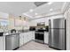 Well-lit kitchen with stainless steel appliances, white cabinetry, and recessed lighting creates a welcoming culinary space at 450 Treasure Isle Causeway # 212, Treasure Island, FL 33706