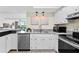 Bright kitchen boasts stainless appliances, white cabinets, pendant lighting, and easy access to the living space at 450 Treasure Isle Causeway # 212, Treasure Island, FL 33706