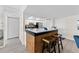 Modern kitchen features a beautiful breakfast bar with granite countertops and wood accents with white appliances and cabinets at 450 Treasure Isle Causeway # 212, Treasure Island, FL 33706