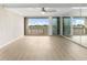 Bright living room with water views, wood floors, ceiling fan, and a mirrored wall at 450 Treasure Isle Causeway # 212, Treasure Island, FL 33706