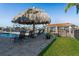 Tropical backyard oasis features a large tiki hut near pool and boat dock on the water at 5133 Glenn Dr, New Port Richey, FL 34652