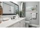 Bright bathroom featuring a vanity with countertop, and framed mirror, and coastal-themed decor at 5133 Glenn Dr, New Port Richey, FL 34652